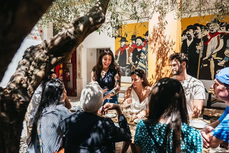 Lisbon: Baixa District Food Tour with Dinner and Drinks - Meeting the guide beneath the Portuguese flag