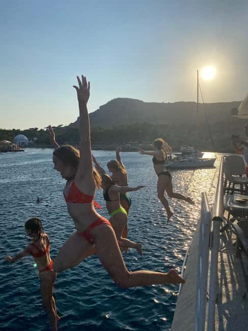 Rhodes: Sunset Cruise w/ Gourmet Buffet, Drinks & Live Music - Leaving Mandraki Port as Rhodes lights up